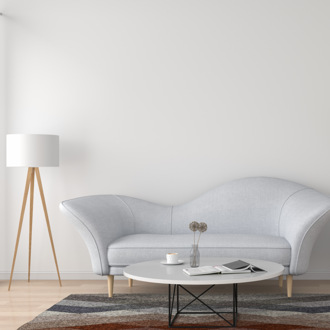 A modern living room includes a light grey curved sofa, a white round coffee table with decor, and a beige floor lamp. The multicolored rug is durable for high-traffic areas and rests safely on the Duralux™ Grip 3 mm by Dura Undercushions, providing non-slip security.